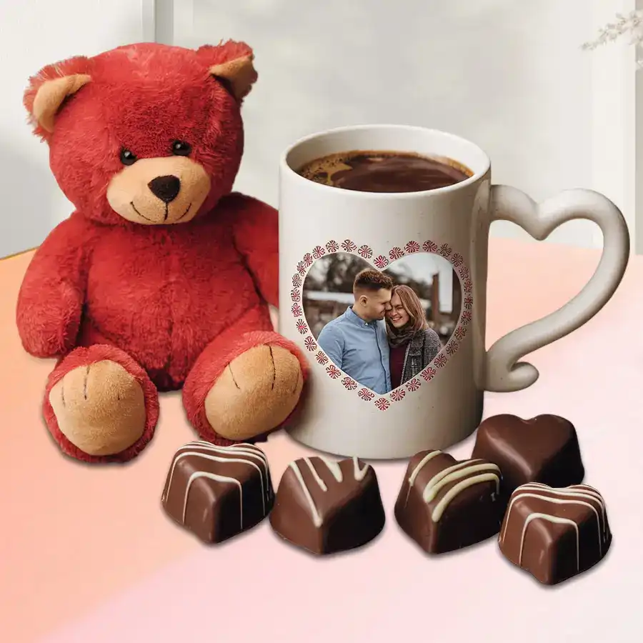 Stunning personalized photo mug with heart handle, heart-shaped chocolates, and a red teddy bear on a festive background.