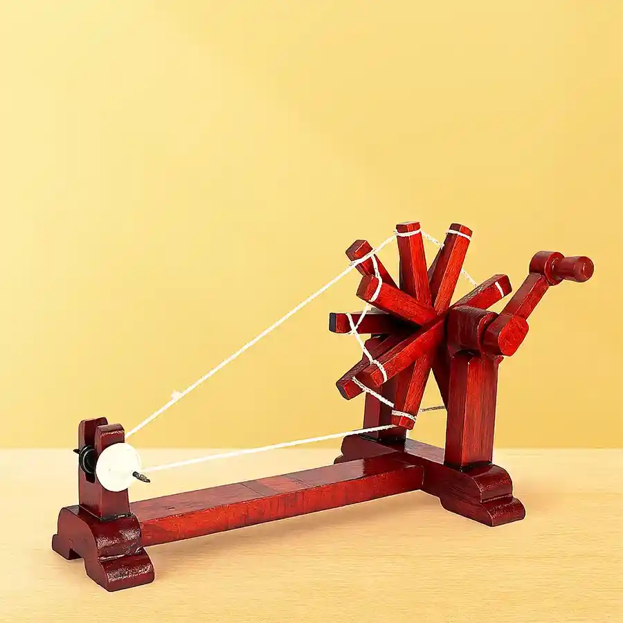 Exquisite wooden Gandhi charkha showpiece, a symbol of peace and heritage, beautifully crafted in brown wood, dimensions 23x14x12.5 cm.