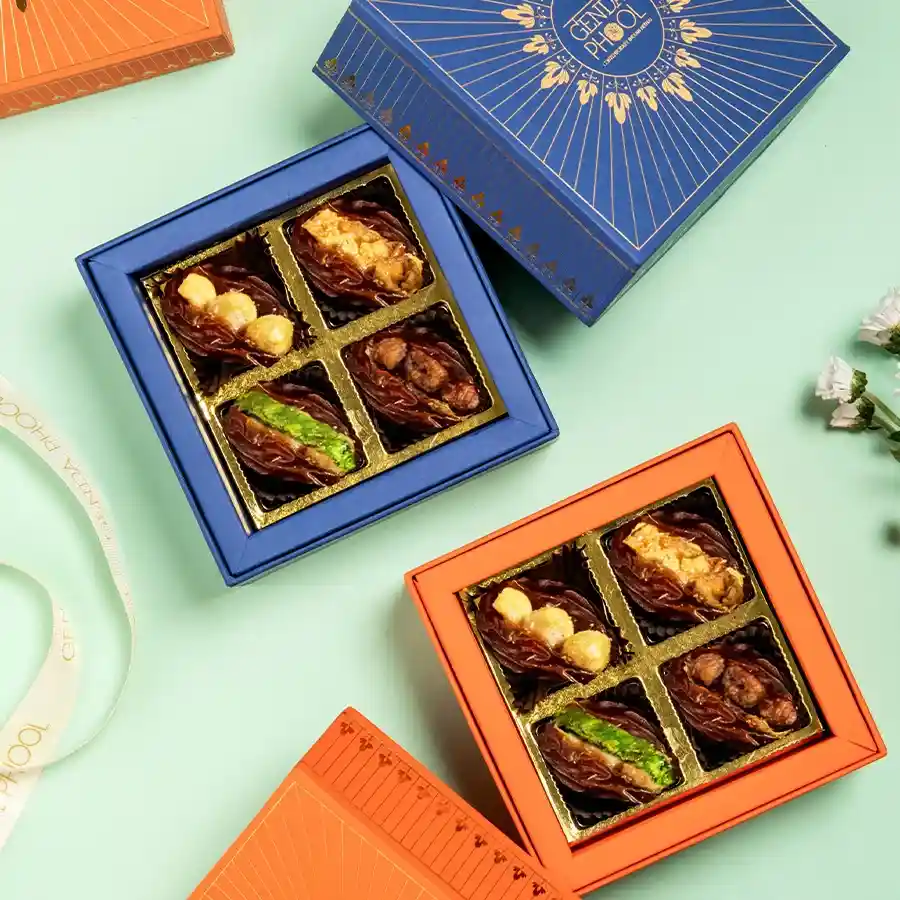 An exquisite gift box containing four stuffed Medjool dates, adorned with 24-carat gold varq and filled with delightful flavors.