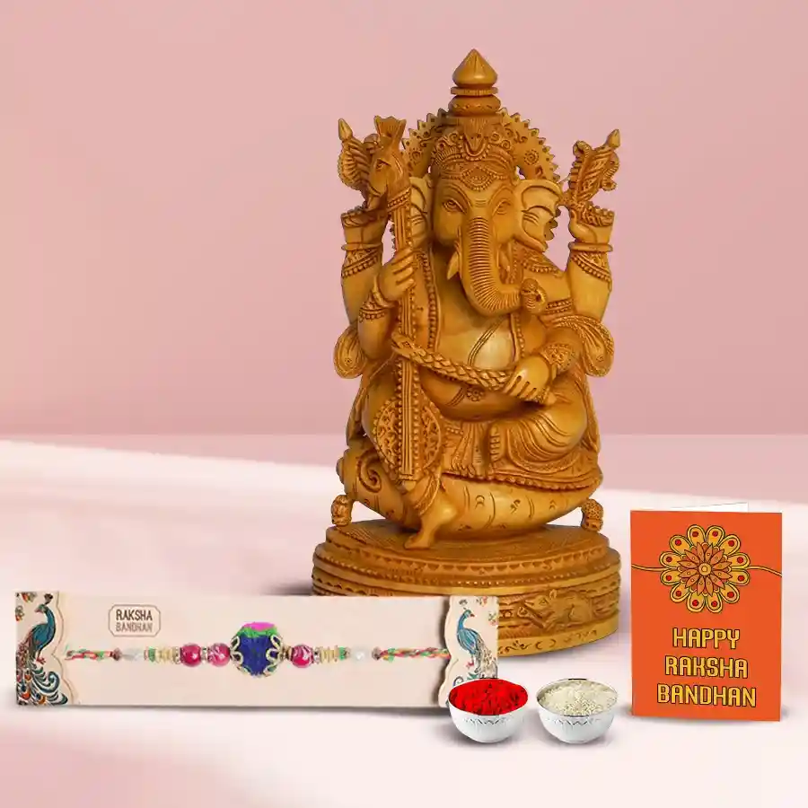 Sandalwood Ganesh statue with a decorative Rakhi placed beside it