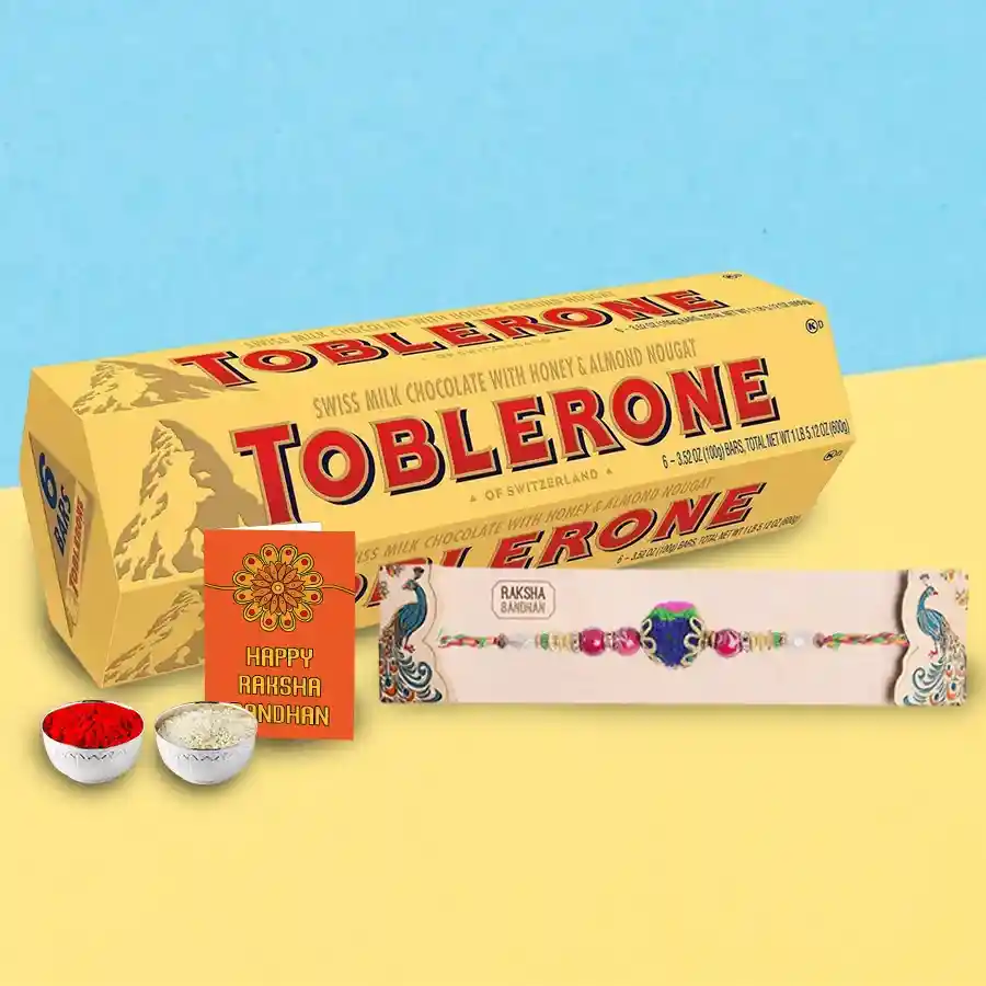 Delightful Toblerone chocolate with complimentary Rakhi, Roli, Tilak, and Chawal on a colorful background