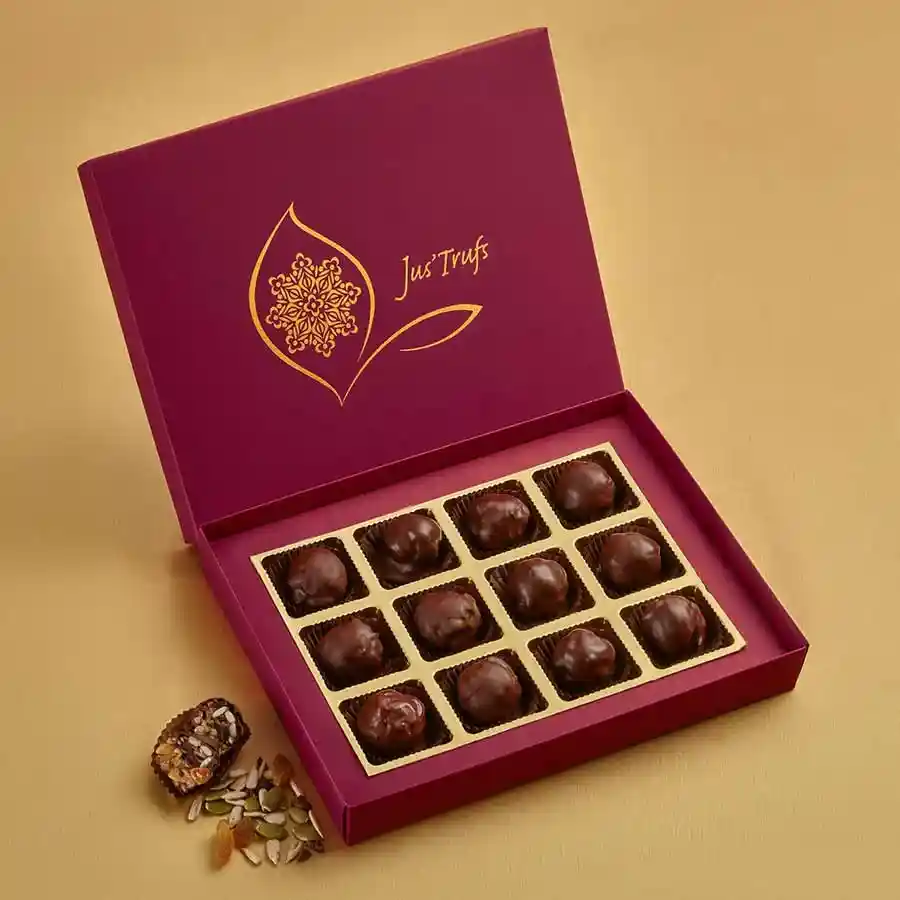 A box of Wholesome Vegan Snack Bites featuring 12 chocolate-coated, bite-sized snacks made from dates, almonds, seeds, and apricots.