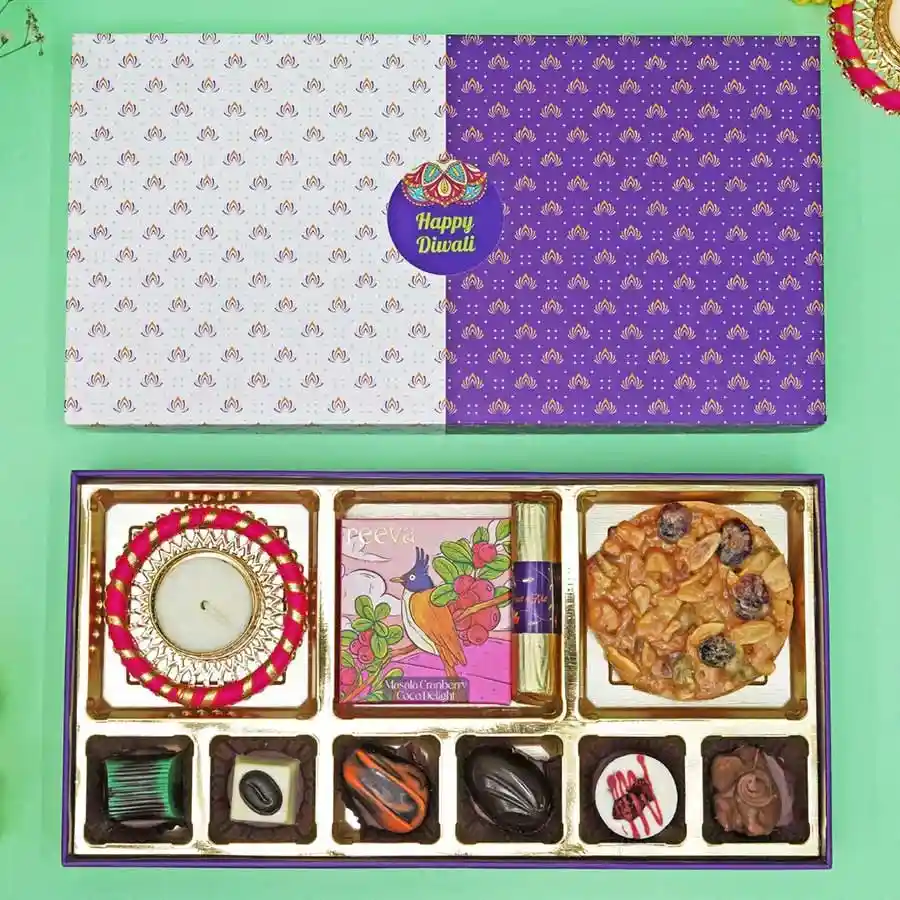 Luxe Chocolate Delight Box with assorted chocolates, a Masala Cranberry Coco Delight Bar, a Fruit & Nut Chocolate Log, a Florentines Cookie, and a crafted Diya.