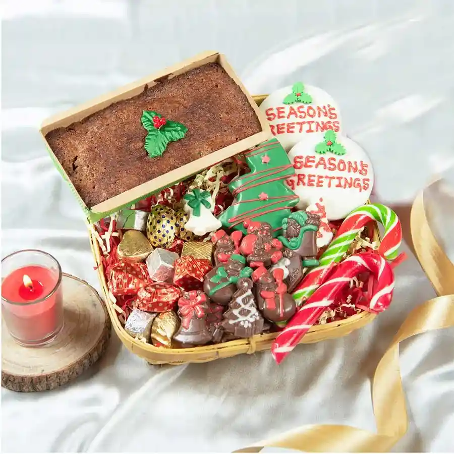 Christmas Joy Chocolate Collection featuring a festive hamper filled with Dark Plum Christmas Cake, assorted gourmet truffles, chocolate-coated butter cookies shaped like Christmas trees, milk and white chocolate Christmas shapes, and edible candy canes.