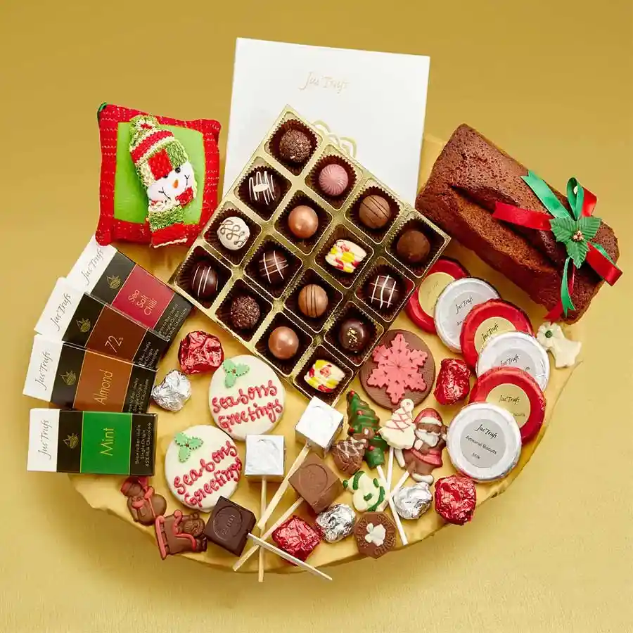 Christmas Sweet Treats Gift Set featuring assorted Belgian pralines, plum cake, chocolate bars, biscuits, lollipops, cookies, hot chocolate sticks, and almond rock chocolates, beautifully presented in a festive box with a Christmas pillow.