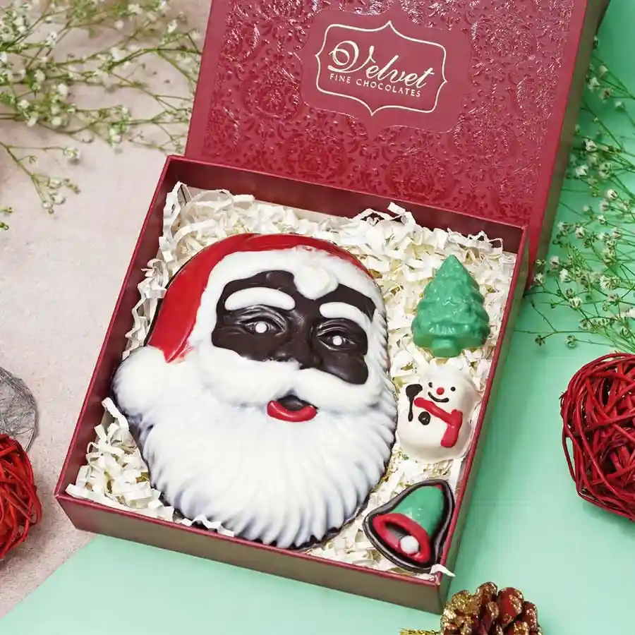 Christmas-themed chocolate treats including a bell, Santa, tree, and a Chocolate Santa Face on a festive background.