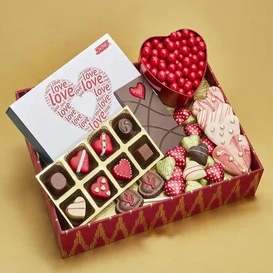 Love N Treats Gift Set featuring assorted truffles, chocolate-coated butterscotch, heart-shaped milk chocolate bar, heart-shaped lollipops, and chocolate butter cookies arranged in a decorative package.