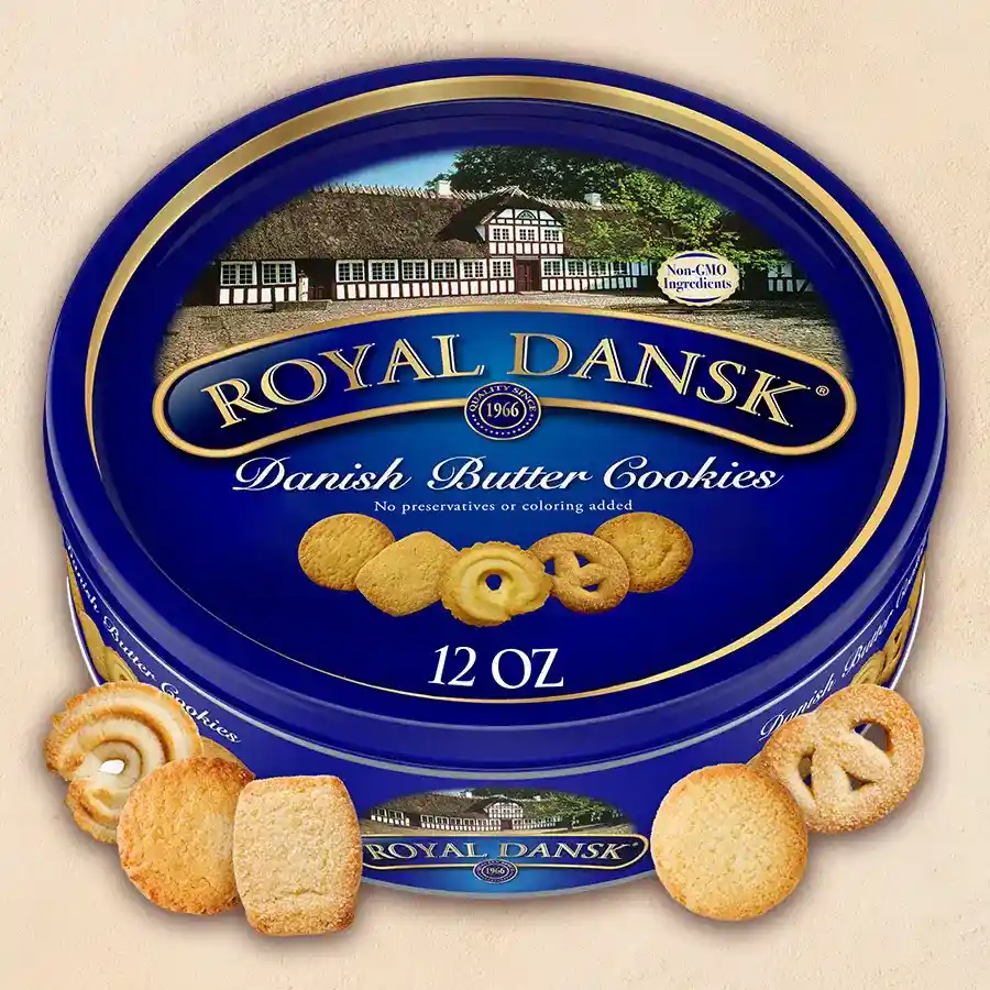 A 500g pack of Fresh Dansk Assorted Cookies featuring various shapes and flavors on a wooden table with a cozy background.