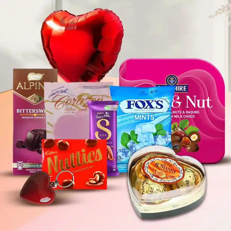 Heightened Ecstasy Array gift box featuring assorted candies, chocolates, a heart-shaped balloon, key ring, and nuts arranged attractively.