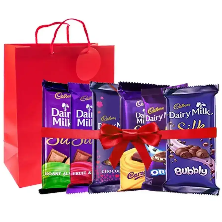 A stylish red handbag filled with an assortment of Cadbury Dairy Milk chocolates, wrapped in a red satin ribbon.