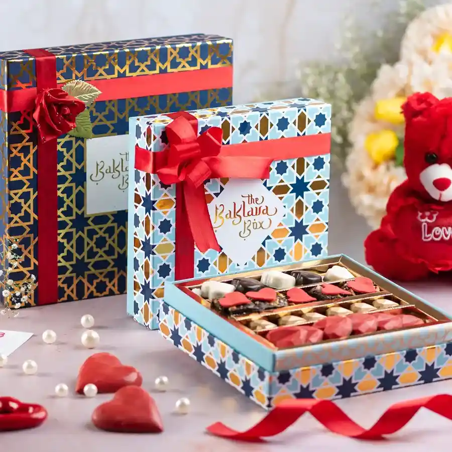 A beautifully packaged gift box containing assorted chocolates and brownies, elegantly tied with a ribbon.