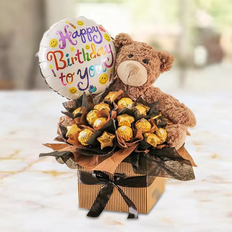 Happy Birthday Gift Hamper featuring Ferrero Rocher chocolates, a teddy bear, and a Mylar balloon in a beautifully crafted box.