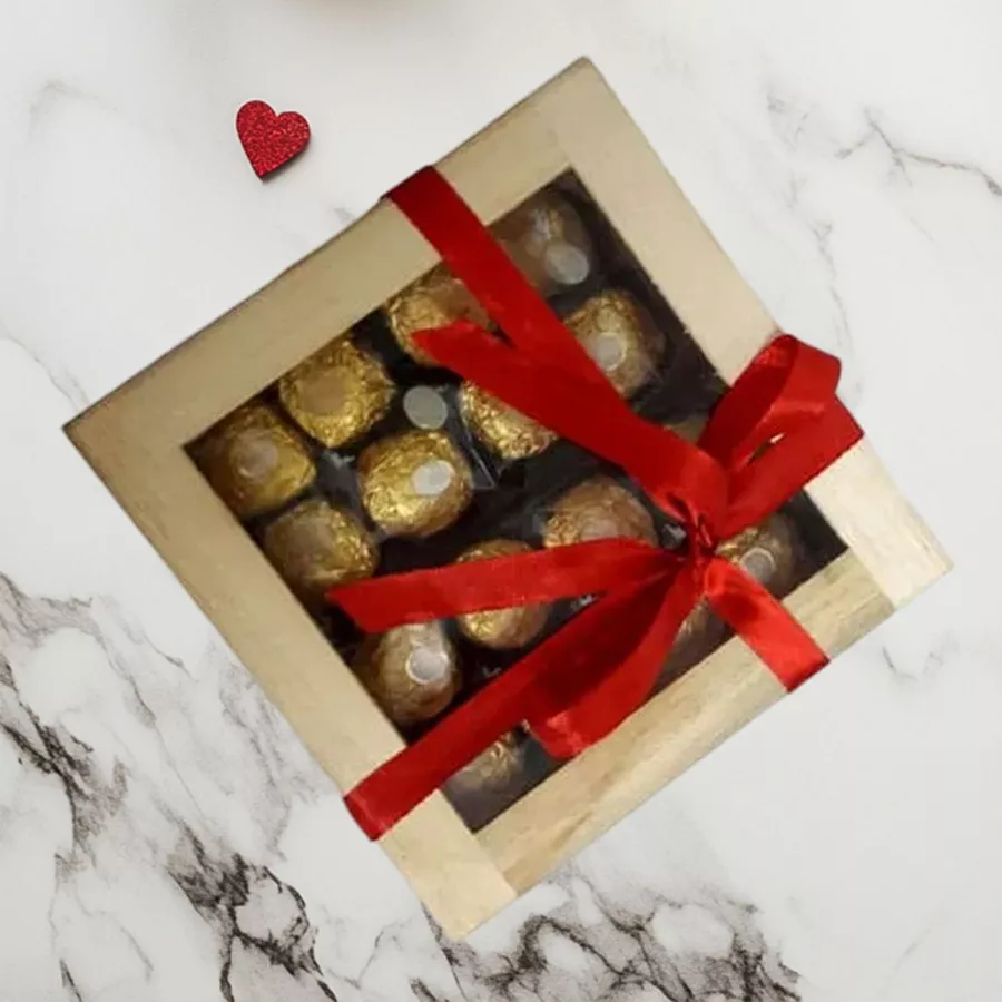 A beautifully crafted wooden gift box containing 16 Ferrero Rocher chocolates, presented elegantly with golden packaging.
