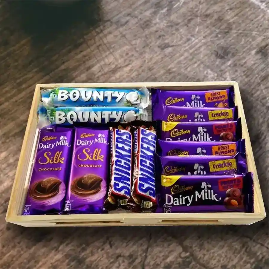 Enticing Birthday Chocolates Hamper featuring Cadbury Dairy Milk Silk, Bounty Coconut Bars, Snickers, assorted chocolates on a premium wooden gift tray