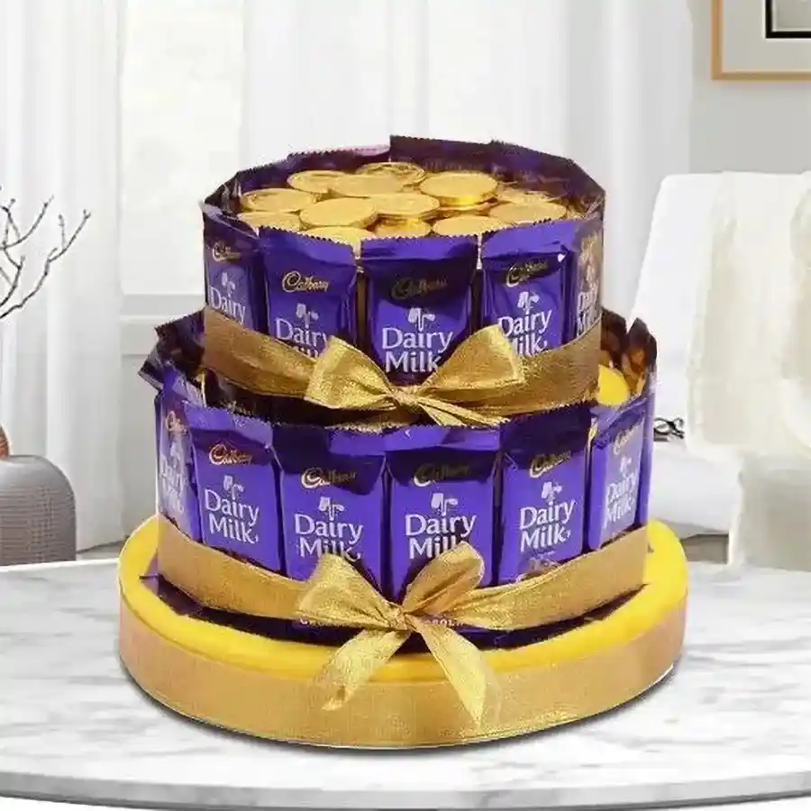 A beautifully arranged tower of Cadbury Dairy Milk chocolates and Gold Coin chocolates, tied with a golden ribbon on a golden base.