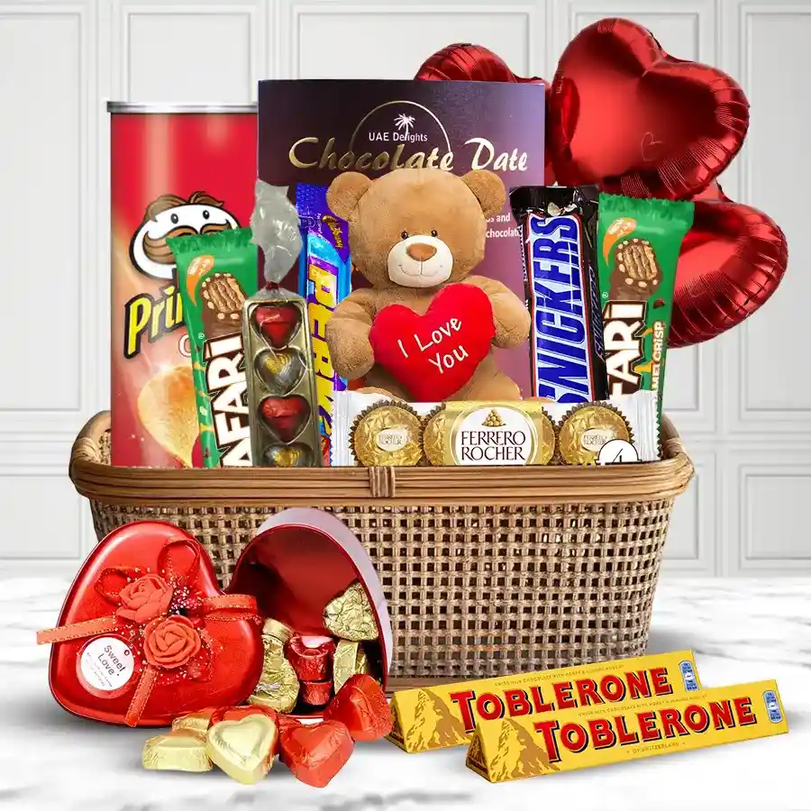 Exquisite Chocolate Gift Basket featuring Toblerone, Ferrero Rocher, handmade heart-shaped chocolates, Snickers, Cadbury Perk, Pringles, chocolate dates, a cuddly teddy bear, and heart-shaped balloons.