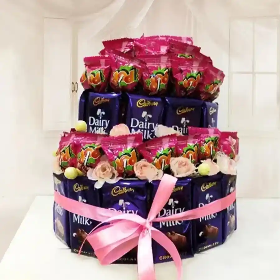 Two-tier arrangement featuring Cadbury Dairy Milk chocolates and lollipops, elegantly wrapped with a ribbon.