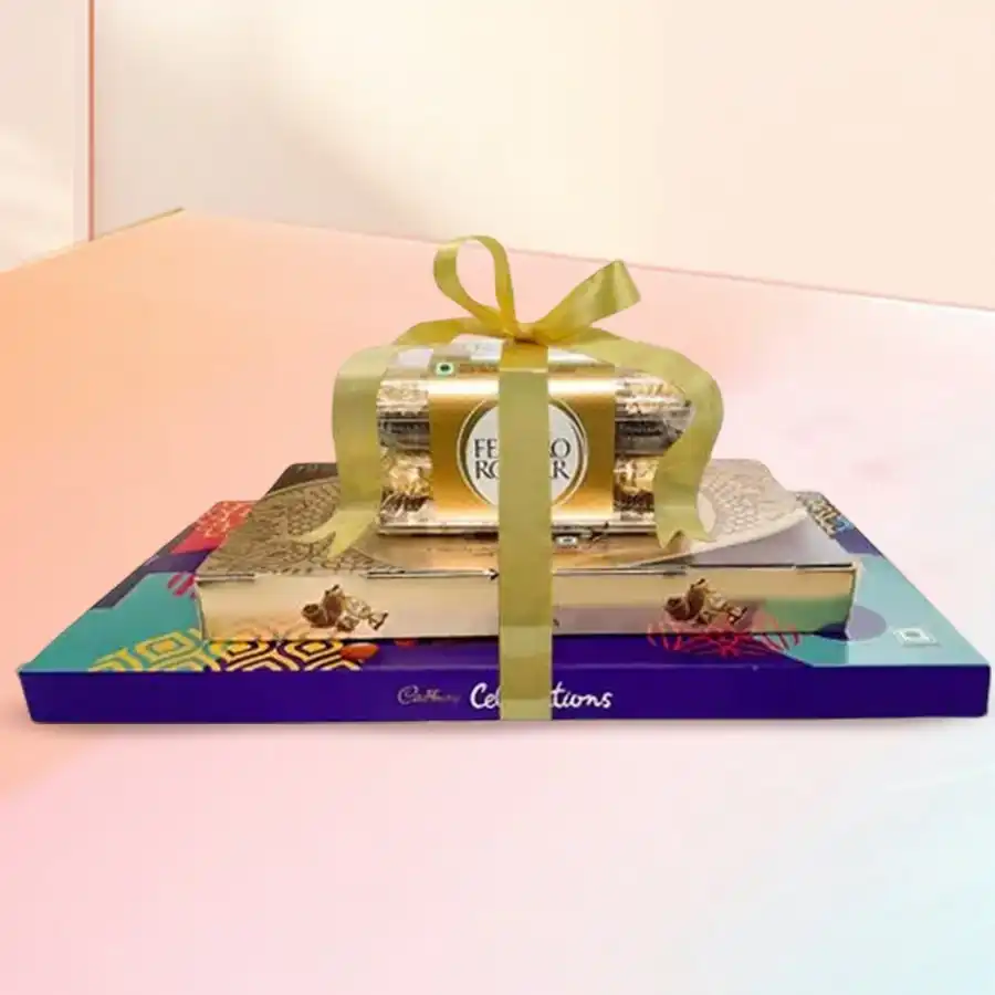 A beautifully arranged Towering Sweet Chocolate Delight featuring Ferrero Rocher chocolates and a Cadbury Celebration Box.