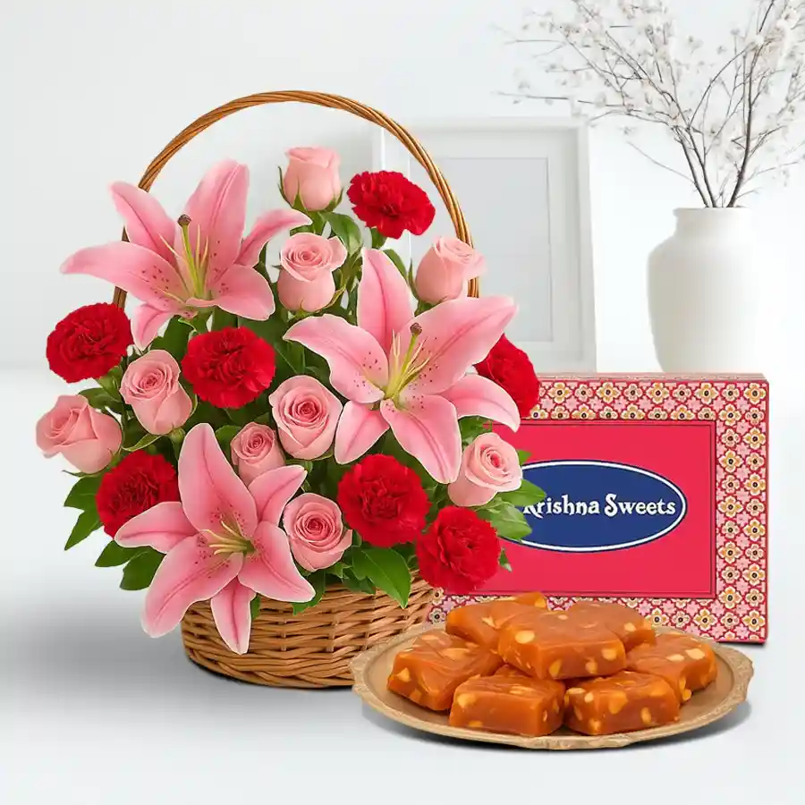 A vibrant arrangement of pink Asiatic lilies, red carnations, and pink roses paired with Bombay Halwa, creating a stunning floral and sweet treat combo.