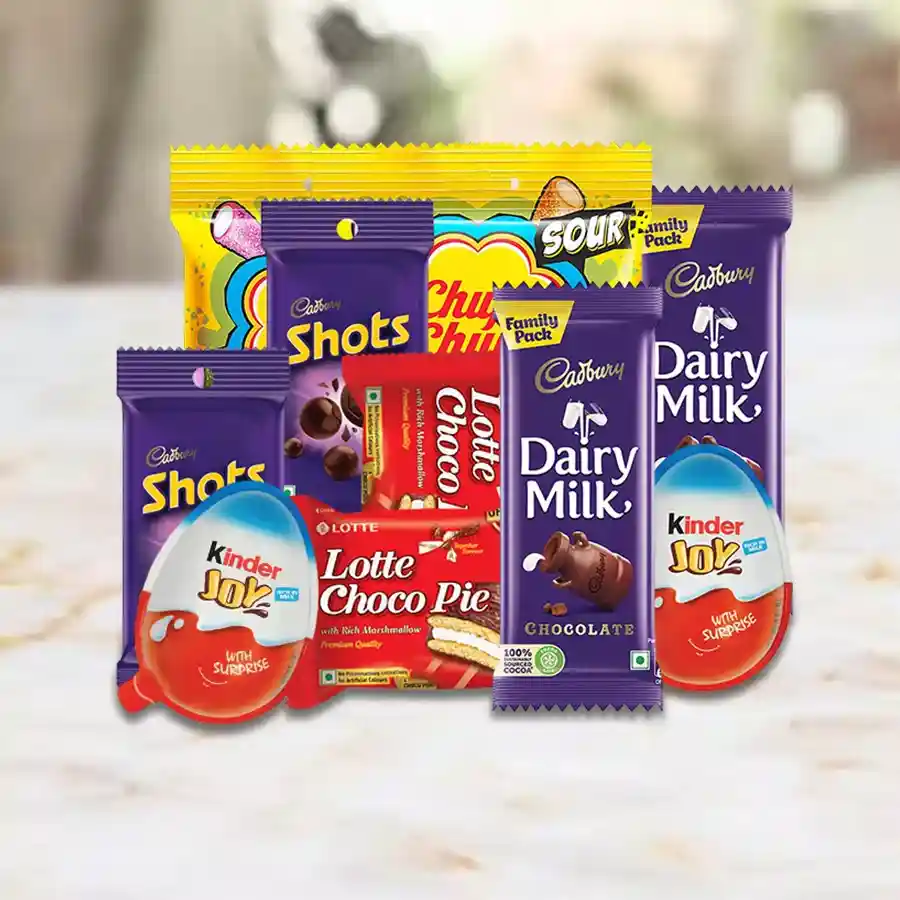 Assorted chocolates for kids including Cadbury Dairy Milk Shots, Kinder Joy, Lotte Chocopie, and Chupa Chups Sour Bites arranged in a colorful display.