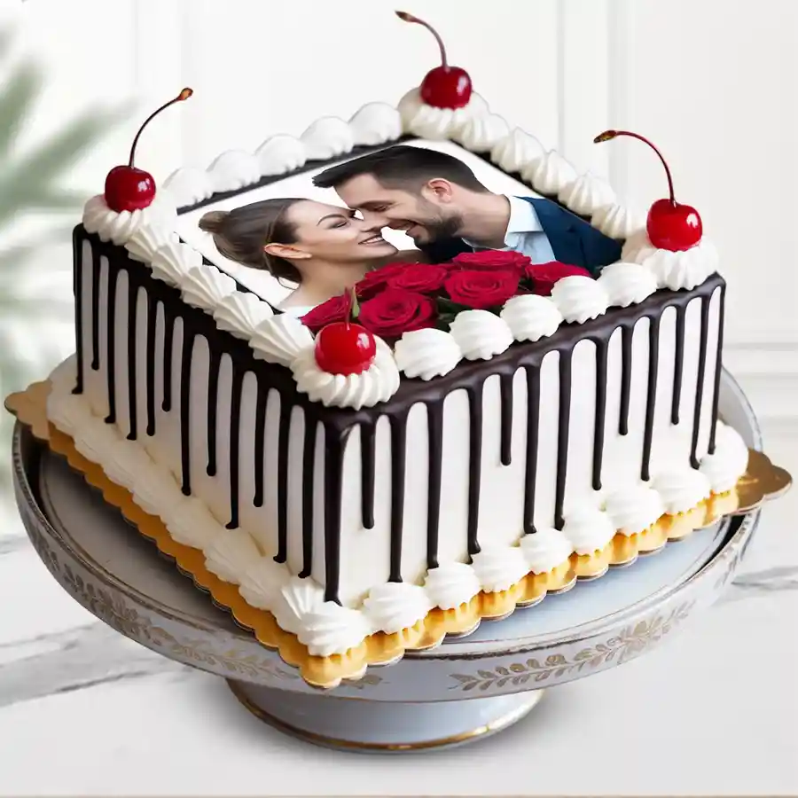 Irresistible Black Forest Photo Cake, square-shaped with cream cheese layers, dark chocolate sprinkles, and fresh red cherries on top.