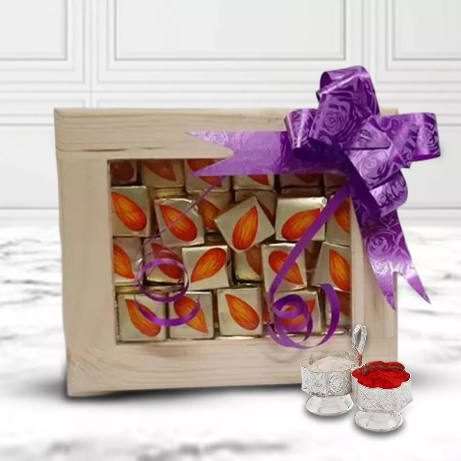Almond chocolates in a wooden box alongside a decorative pooja thali, with a Bhai Dooj tika and chawal set for celebration.