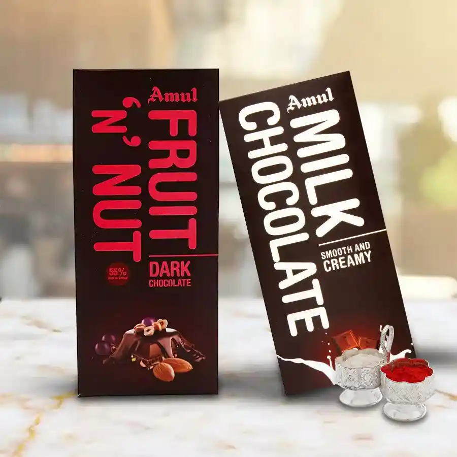 Two Amul chocolate bars - creamy milk chocolate and crunchy fruit & nut, with Bhai Dooj Tika and Chawal on a festive background.