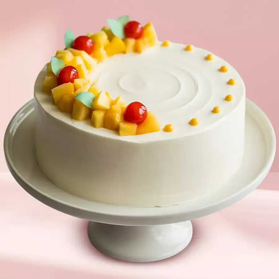 Heart-shaped pineapple cake topped with whipped cream, pineapple flower, and cherry.