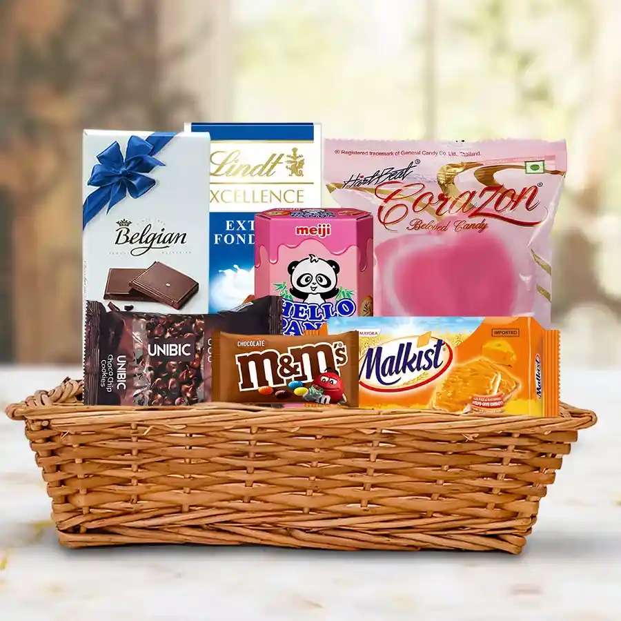 Yummy Chocolate Gift Hamper featuring assorted chocolates, cookies, and biscuits arranged in a small basket.