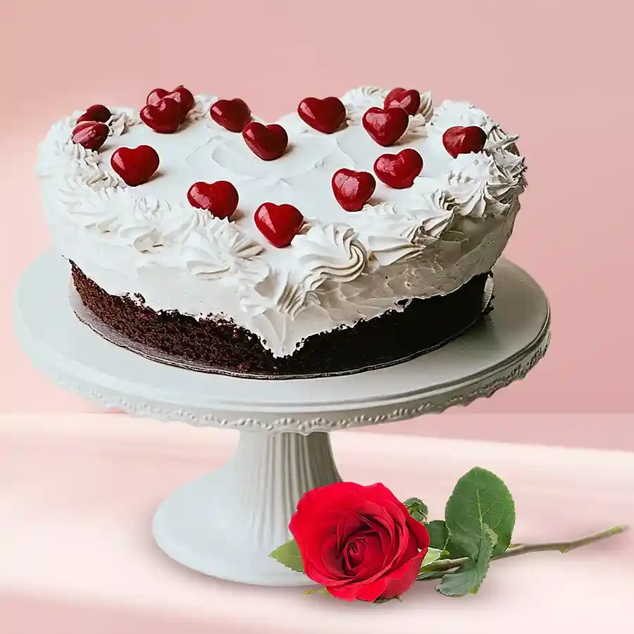 Heart-shaped Black Forest cake paired with a single red rose.
