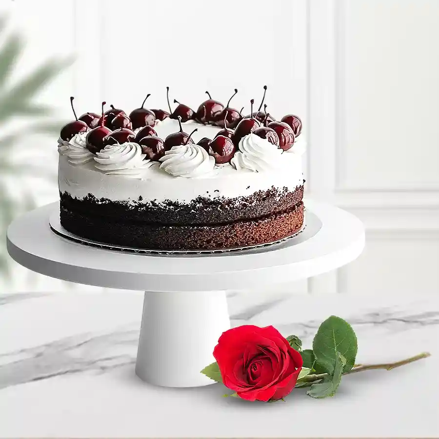 A rich eggless Black Forest cake accompanied by a single rose, perfect for heartfelt gifting.