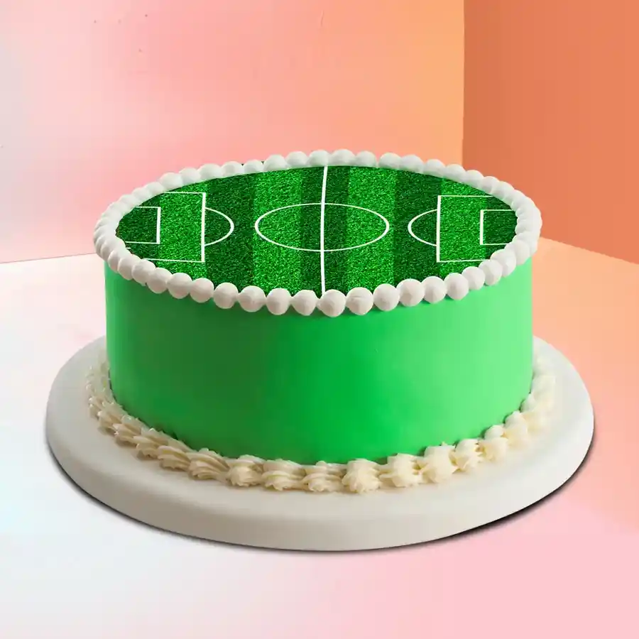 A 1.5 kg football field cake designed for kids' celebrations, featuring vibrant green icing and football-themed decorations.