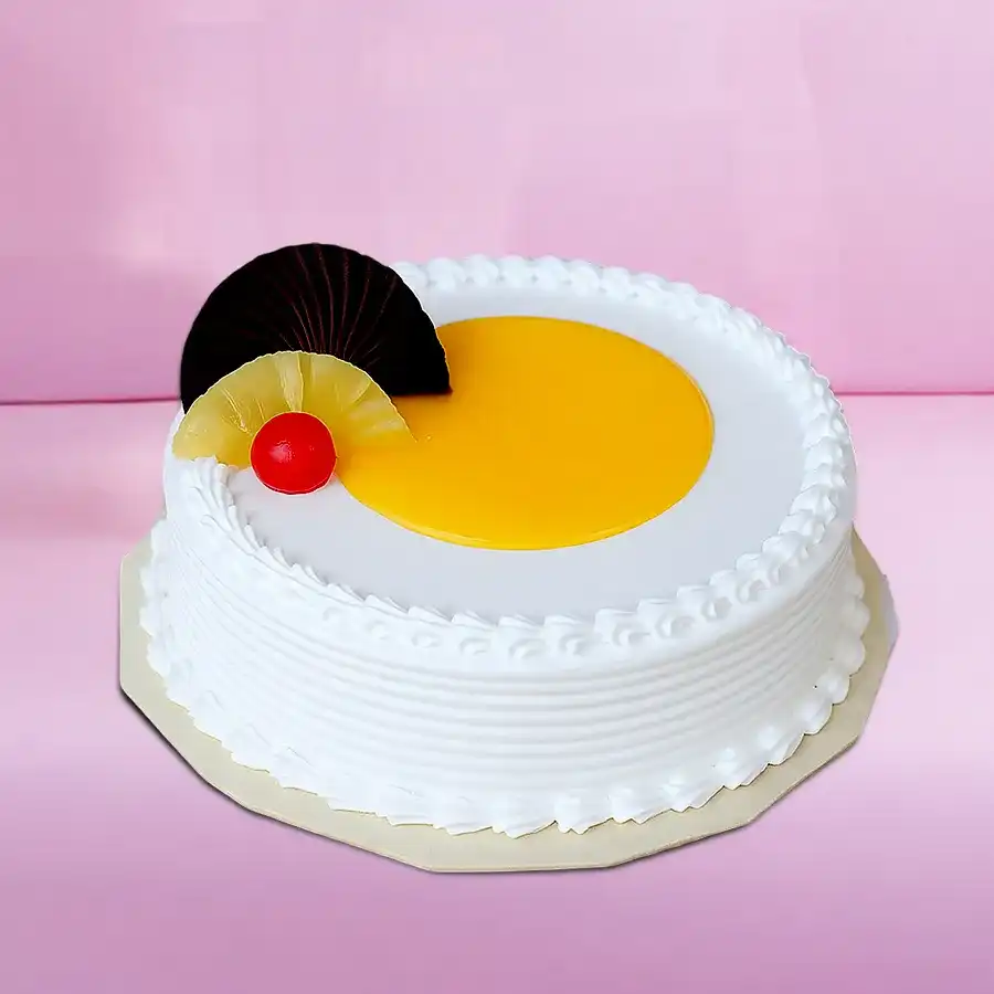Eggless Fresh Cream Pineapple Cake with pineapple slices on top.