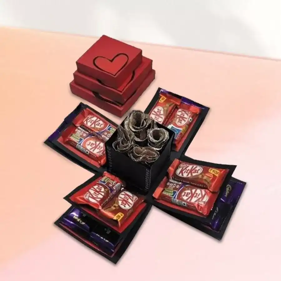 Triple layer explosion box filled with Cadbury Dairy Milk chocolates, Nestle KitKats, and fresh roses
