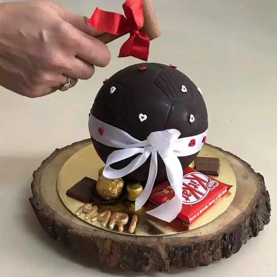 A delightful Designer Smash Cake with hammer and assorted chocolates, perfect for celebrations.