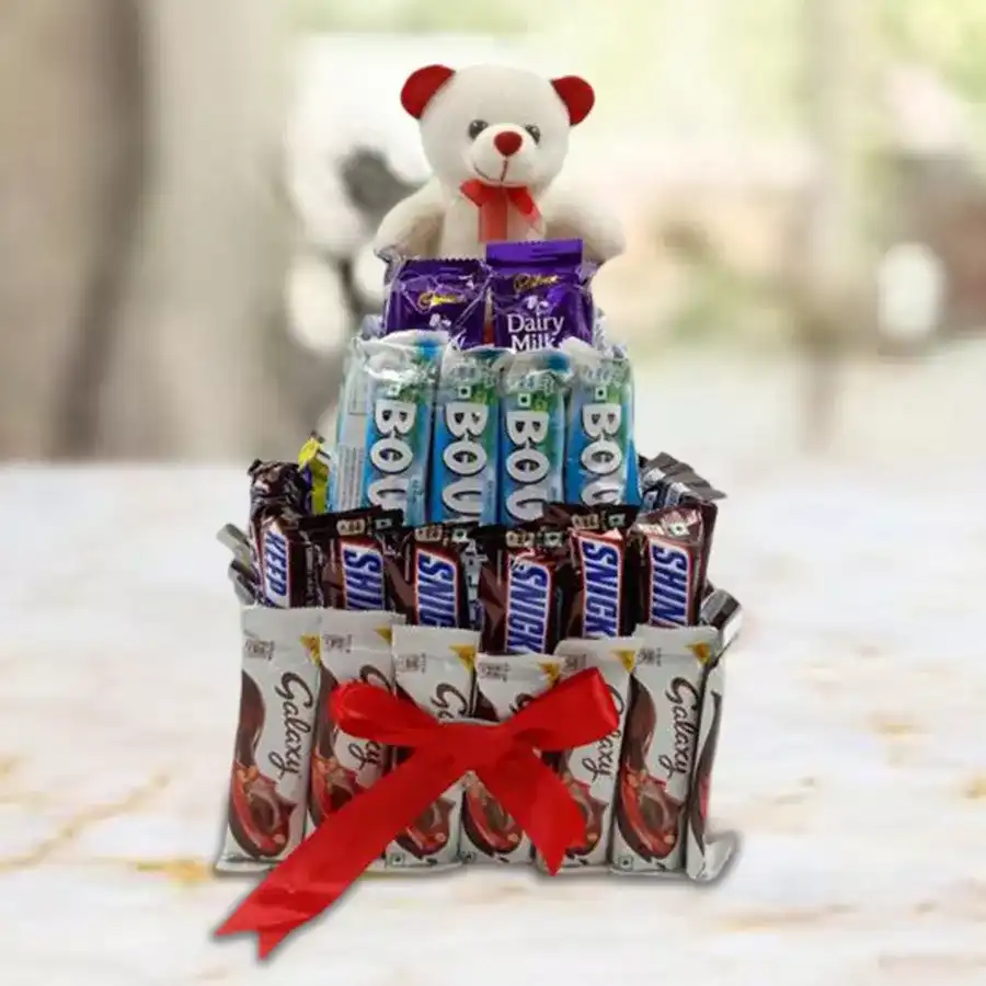 4 tier tower arrangement featuring mixed chocolates and a 6-inch teddy bear