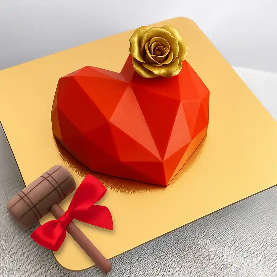 Delectable red heart-shaped smash cake with rose fondant and hammer.