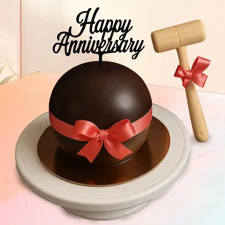 Round chocolate pinata cake with hammer for smashing.
