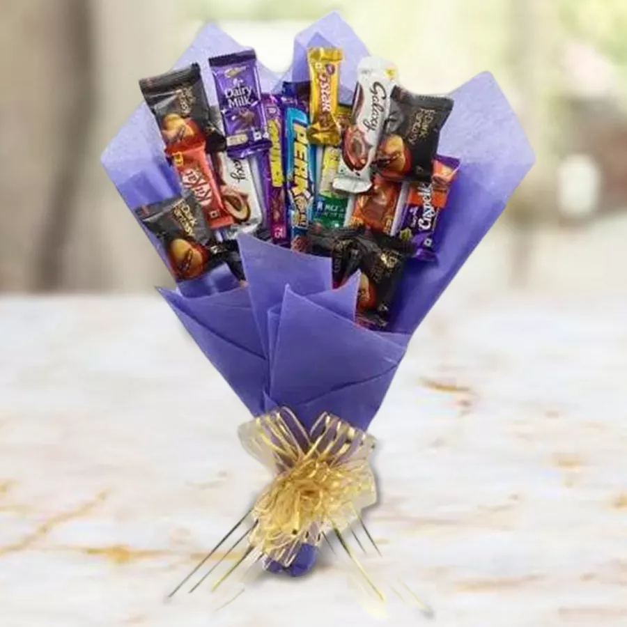 Enigmatic hand arrangement featuring a variety of chocolates and cookies in a decorative gift basket