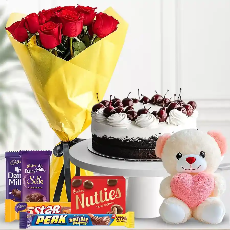 Heartfelt gift hamper with red roses, a cake, chocolates, and a teddy bear.