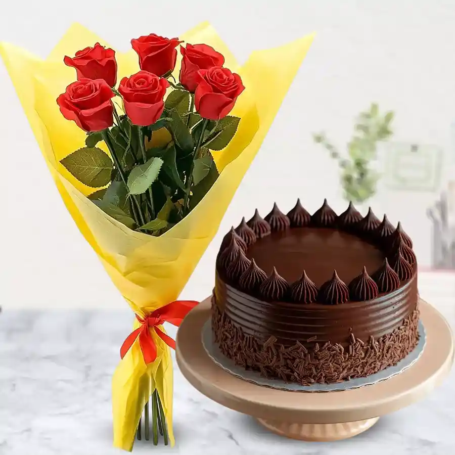 Hand bunch of red roses with chocolate cake, elegantly wrapped.