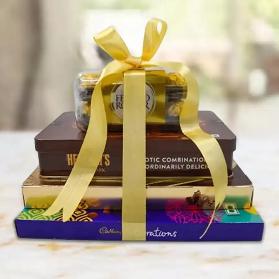 Delightful 4 Layer Chocolate Tower Gift featuring Ferrero Rocher Moments, Hershey’s Exotic Dark Kisses, Cadbury Celebration assortments, and Ferrero Hazelnut Chocolates arranged elegantly.