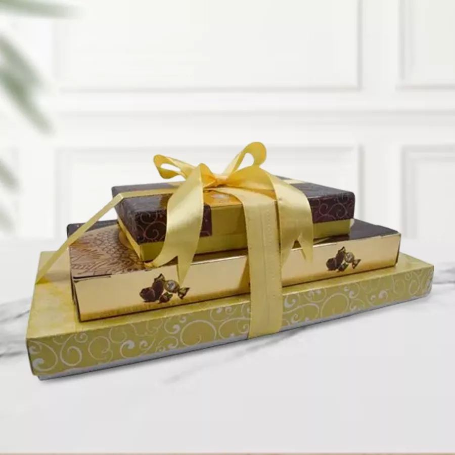 A beautifully arranged gift tower featuring a 100g truffle chocolate box, a 400g assortment of mixed dried nuts, and a 16-piece Ferrero Rocher Moments box, all presented in an elegant stacking display.
