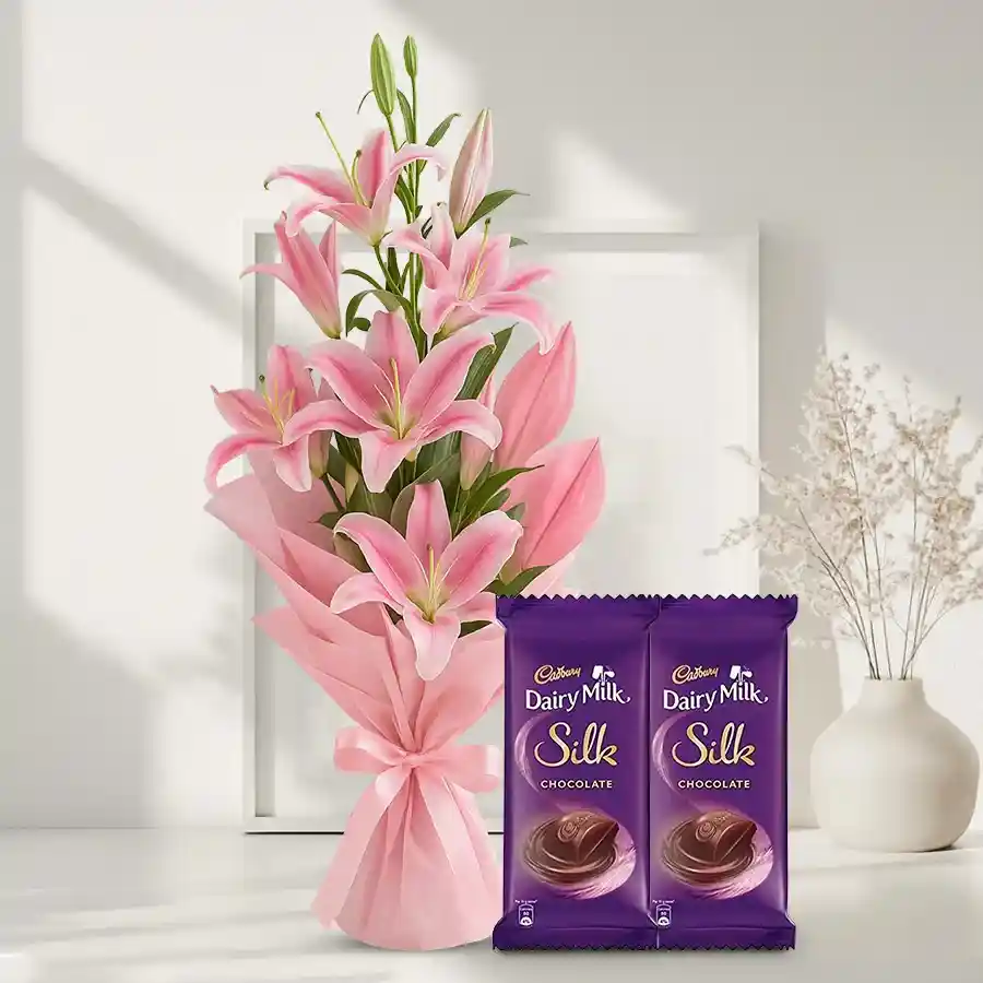 A luxurious bouquet of pink lilies accompanied by Cadbury Dairy Milk Silk chocolates, ideal for gifting on special occasions.