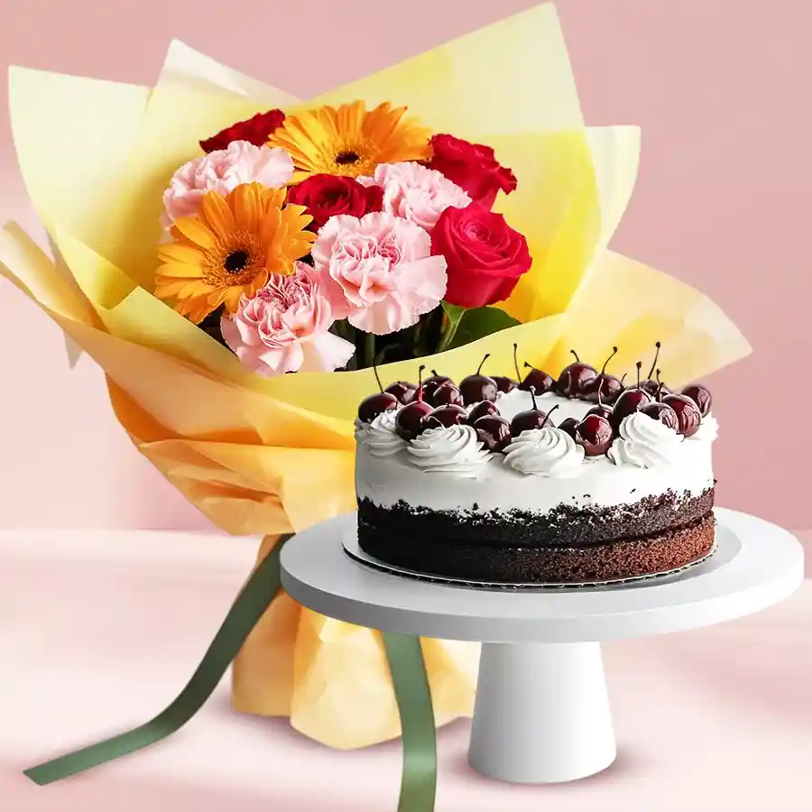 A beautiful gift hamper featuring a mixed flower bouquet with Gerberas, Carnations, Roses, and a delicious 1 lb Black Forest Cake.