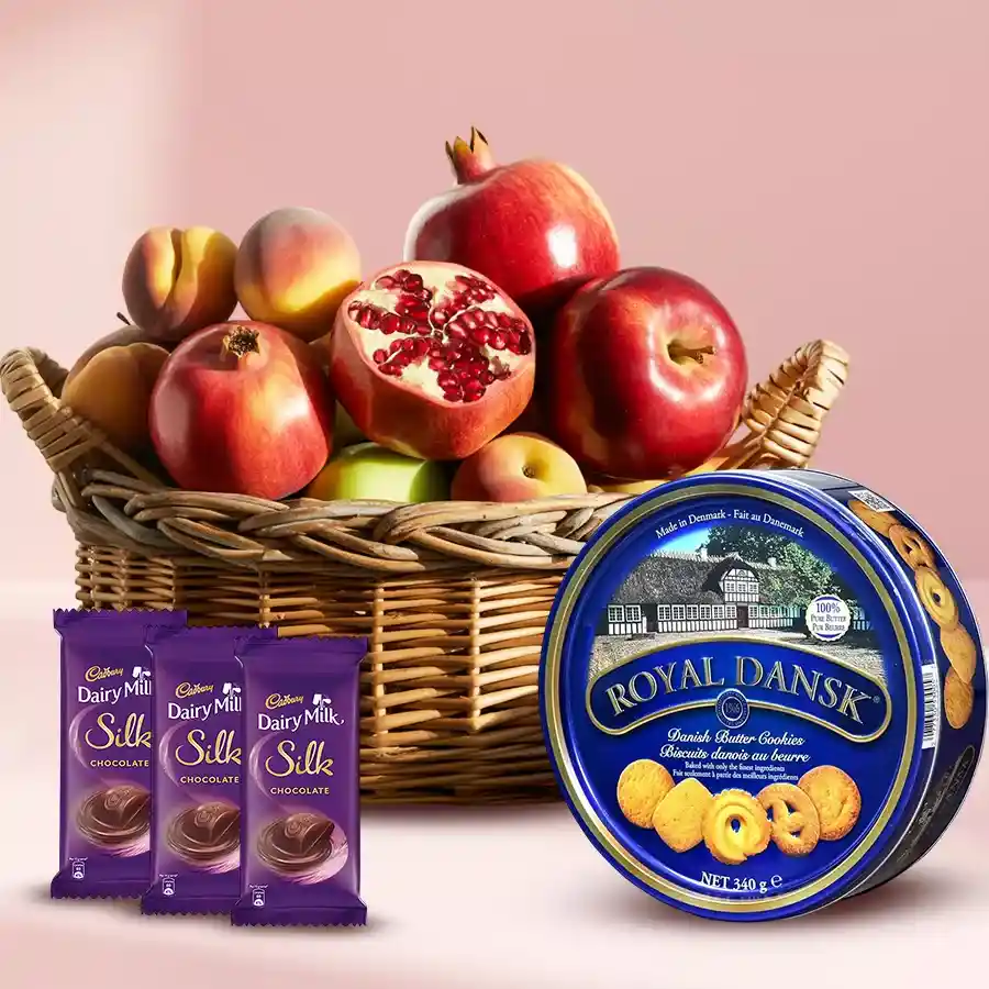 Exquisite basket featuring Danish cookies, Cadbury chocolates, and fresh fruits including apples and pomegranates.