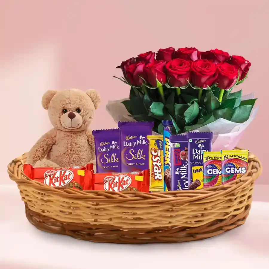 A delightful gift basket featuring red roses, assorted chocolates, and a plush teddy bear, perfect for sharing love and joy.