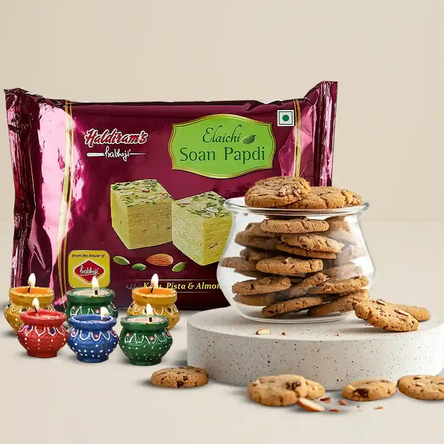 Delightful Diwali gift set featuring Soan Papdi, assorted cookies, and decorated diyas. Perfect for celebrating the festival of lights.