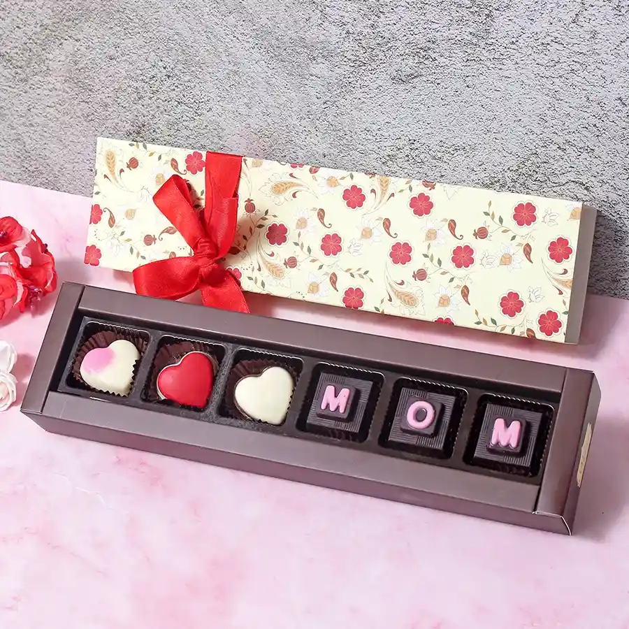 Beautiful Mom Surprise Chocolate Box featuring six assorted chocolates stamped with "MOM" in an elegant floral-printed box.