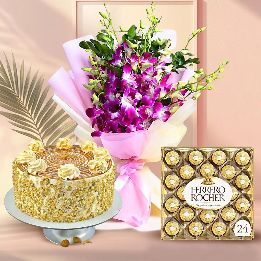 A beautiful arrangement of blue orchids in a vase accompanied by a round butterscotch cake and 24 Ferrero Rocher chocolates.